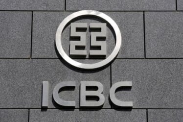The silver-grey circular ICBC corporate logo on the charcoal-coloured facade of a building
