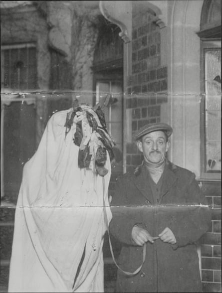 A man with a horse skull covered a sheet and ribbons