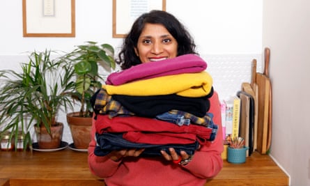 Chitra Ramaswamy holding a stack of folded clothes.
