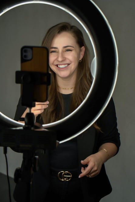 woman smiles in front of ring light for appearing in online videos
