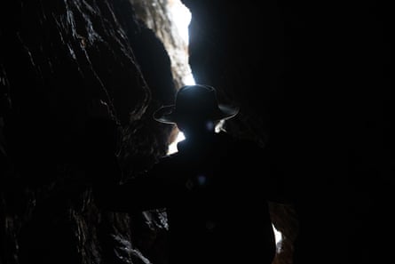 Alison Lester silhouetted against the sky nestled between the shade of two rock walls