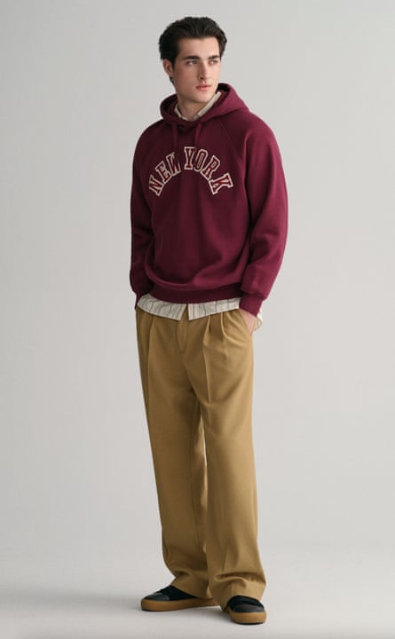 Male model in burgundy hoodie and beige trousers