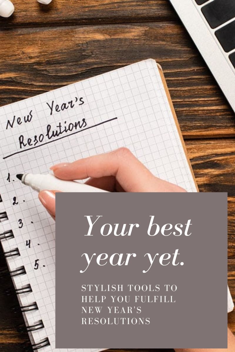 Close view of hand writing out New Year's resolutions in a spiral bound book. 