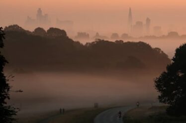 A misty morning with London’s skyline in the background and cyclists in the foreground