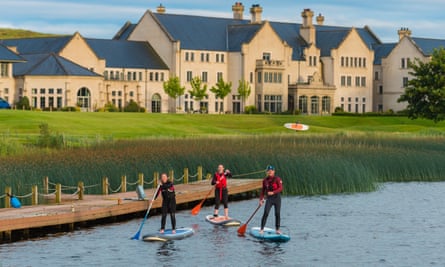 Paddle boarding on Lough Erne in Enniskillen with the turreted resort buildings behind.