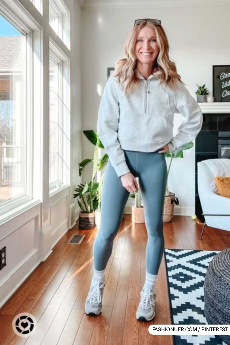 Chic soccer mom outfit with gray hoodie and blue leggings in a stylish home interior.