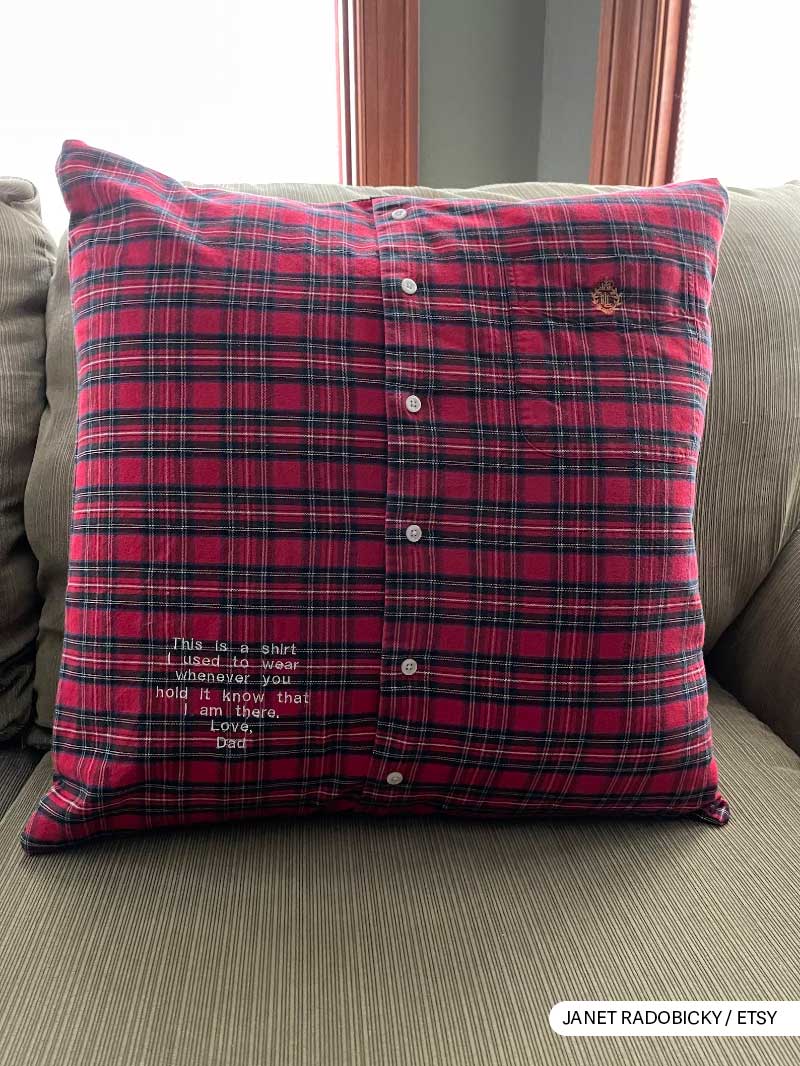 Red plaid shirt pillow with a loving message from Dad on a cozy sofa.