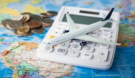 Coins, a calculator and a model plane on a map