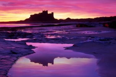 View across the beach at sunset at Bamburgh Castle, Northumberland.
