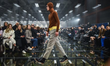 A model wearing Prada menswear walks past members of the audience at Milan fashion week