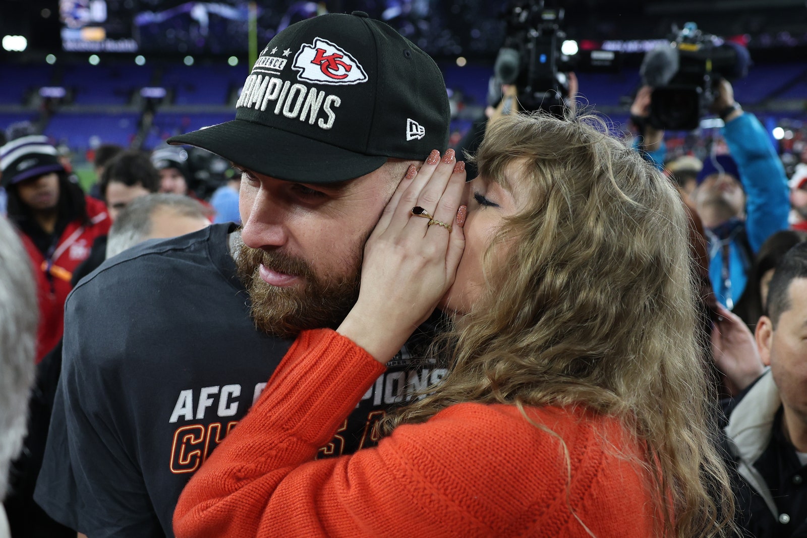 Travis Kelce 87 of the Kansas City Chiefs celebrates with Taylor Swift as she whispers in his ear after a 1710 victory...