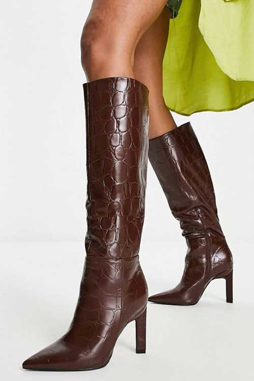 Knee high brown faux leather boots in crocodile pattern.