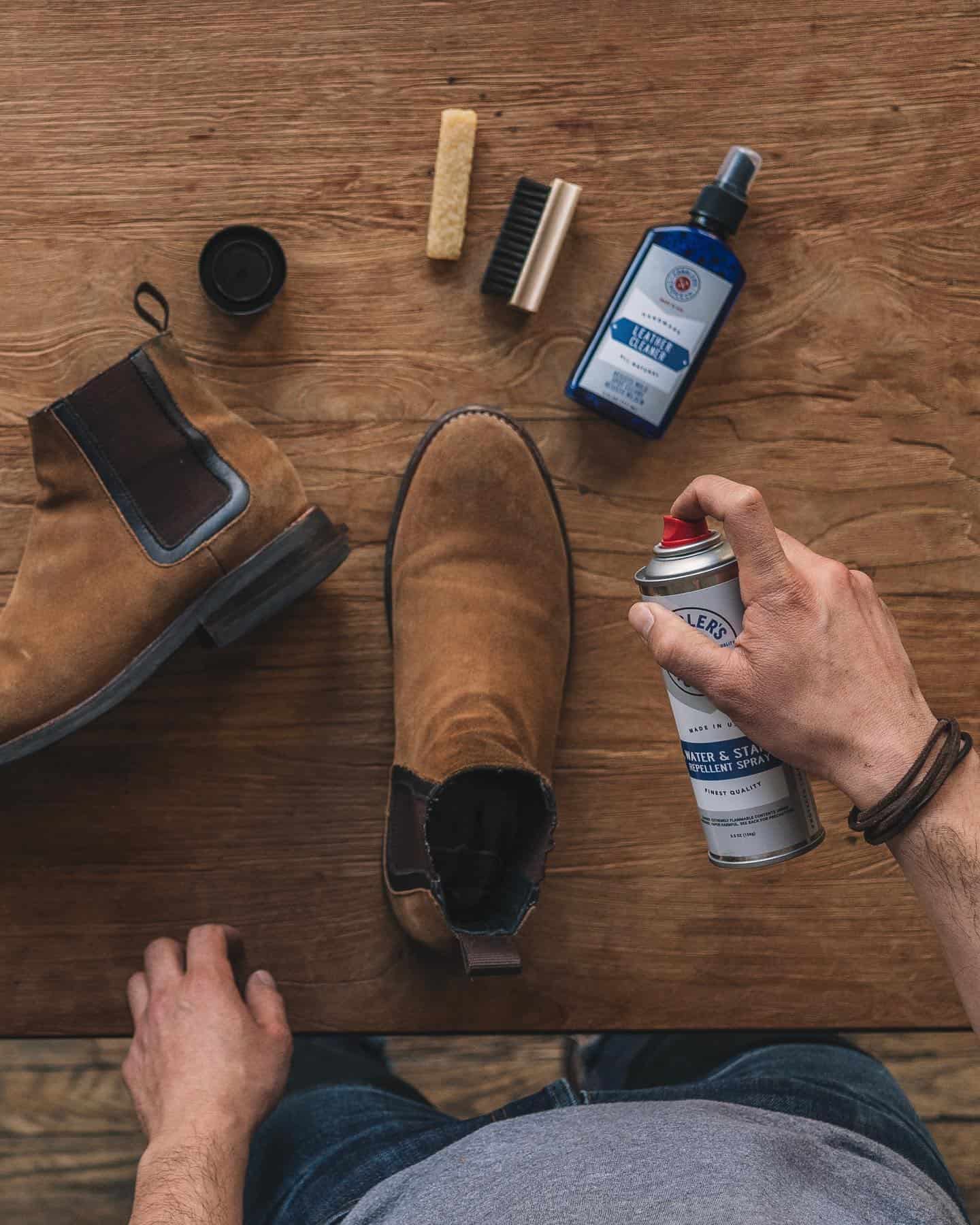 spraying boots with water and stain repellent spray