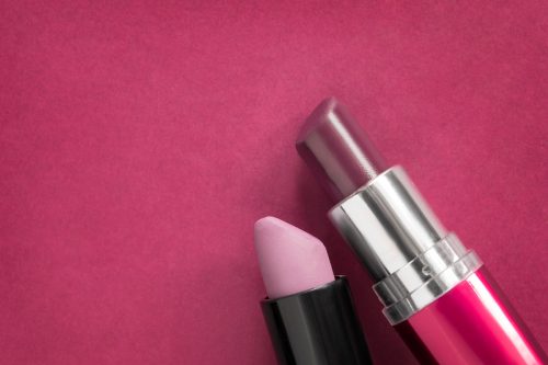 pink and red-brown lipstick on pink background