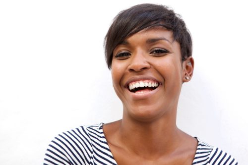 Close up portrait of a happy Black woman with a pixie cut against a white background