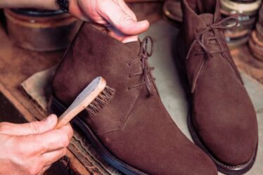 cleaning a pair of suede boots with a brush