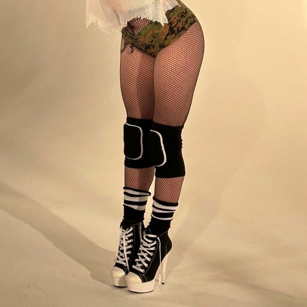 Billie Eilish wearing fishnets with knee pads
