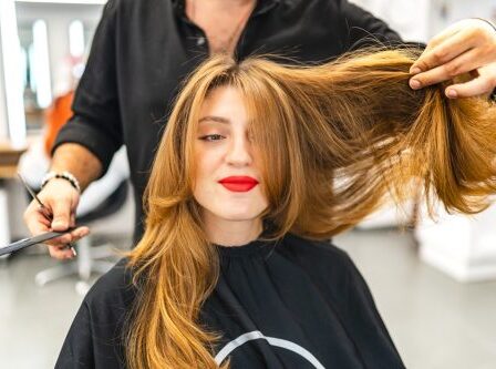 Beautiful young woman getting her hair cut