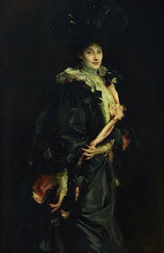 Lady Sassoon in a black cape.