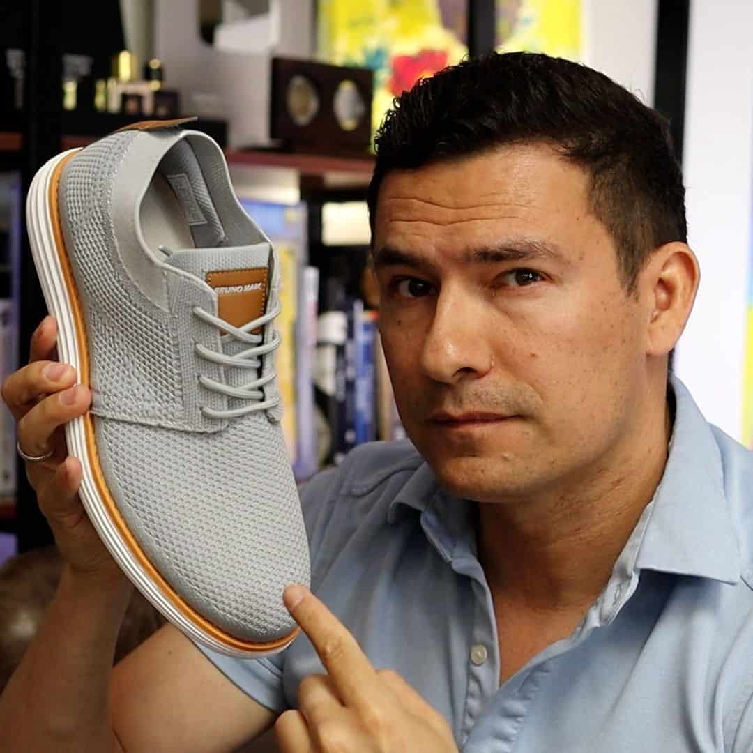man holding to a fabric fashion sneaker by bruno marc