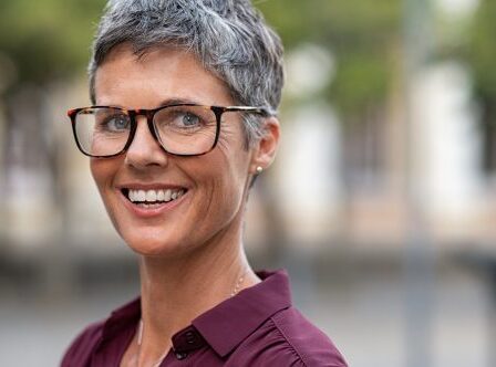 Portrait of businesswoman with gray hair wearing eyeglasses while looking at camera.