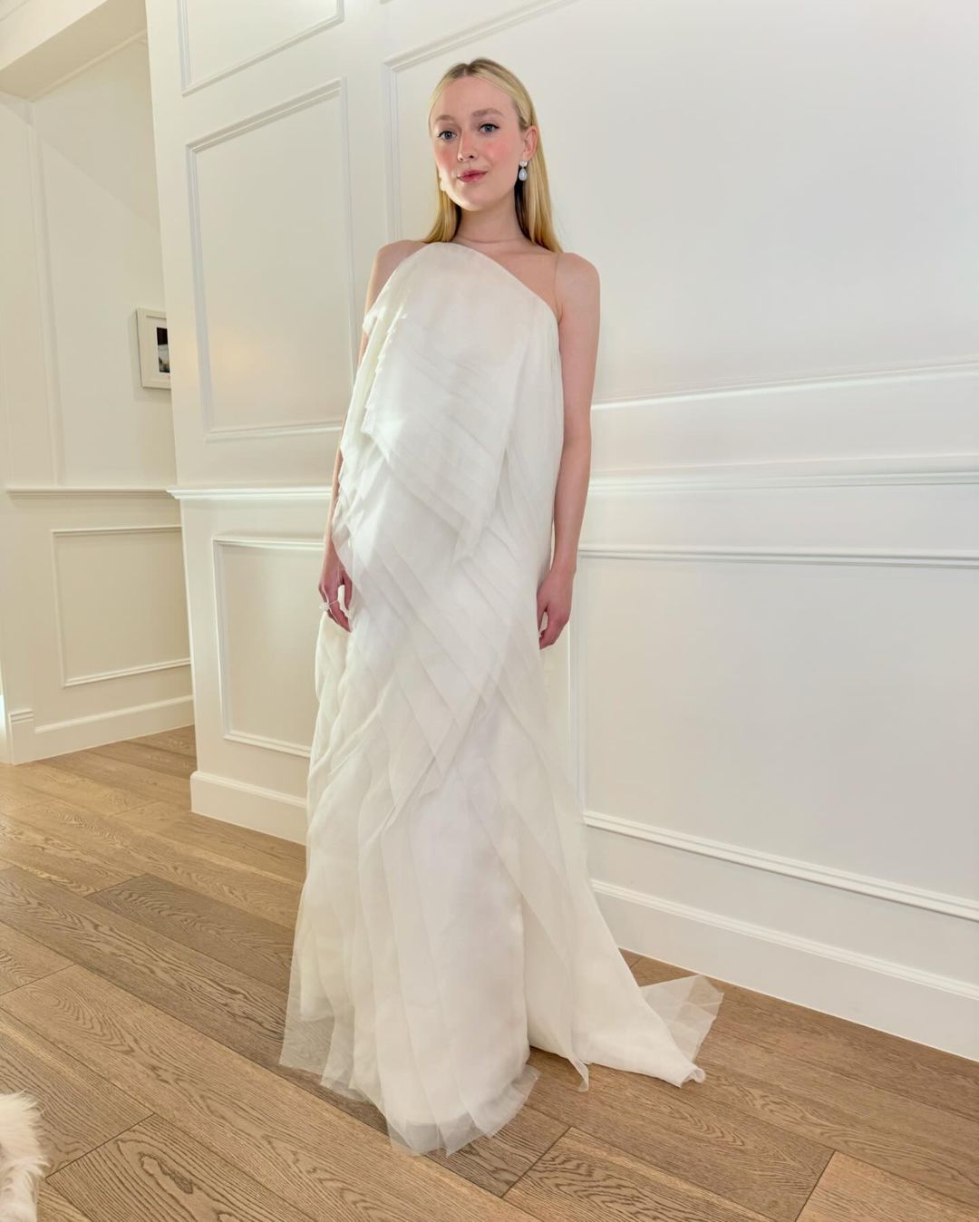 Image may contain Dakota Fanning Clothing Dress Formal Wear Fashion Gown Wedding Wedding Gown Person and Standing