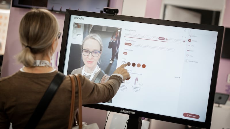 An attendee to Cosmoprof Worldwide 2024 in Bologna tries out an AR tool for a beauty product