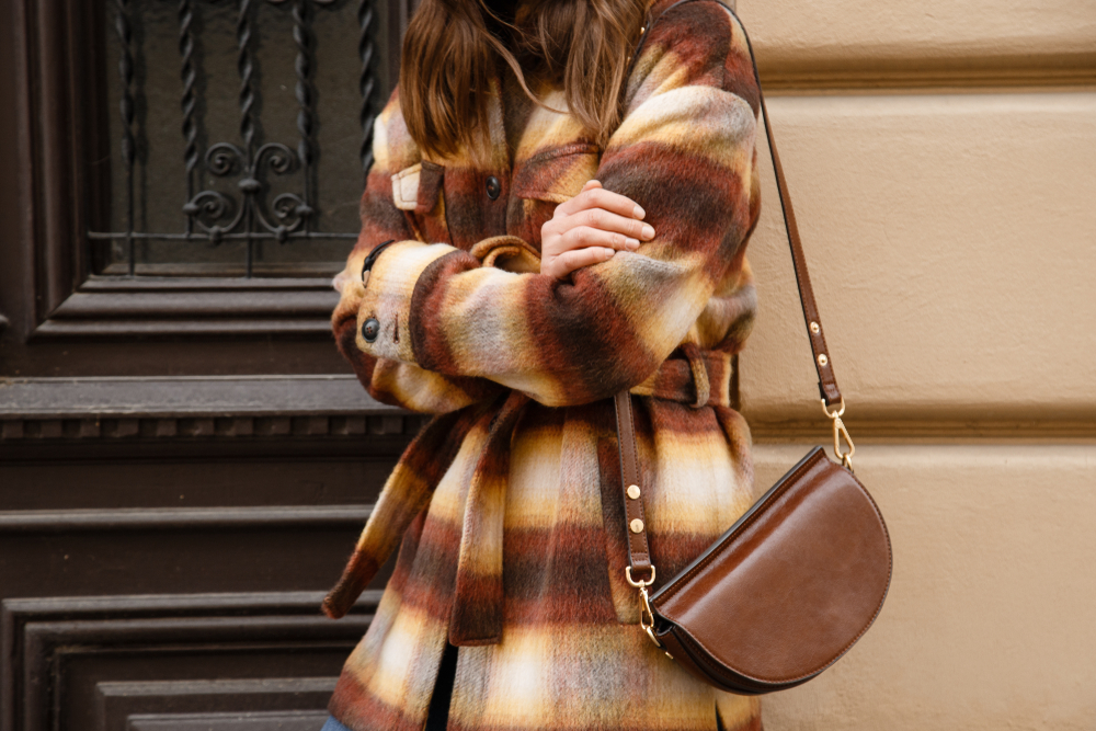 woman wearing plaid flannel wool jacket and brown purse