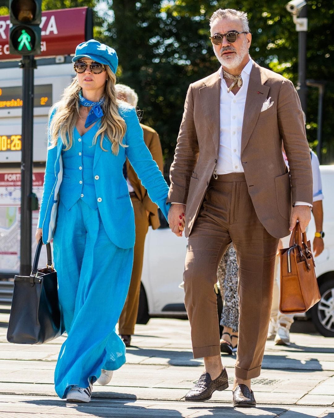 chic man and woman holding hands, both in casual suiting