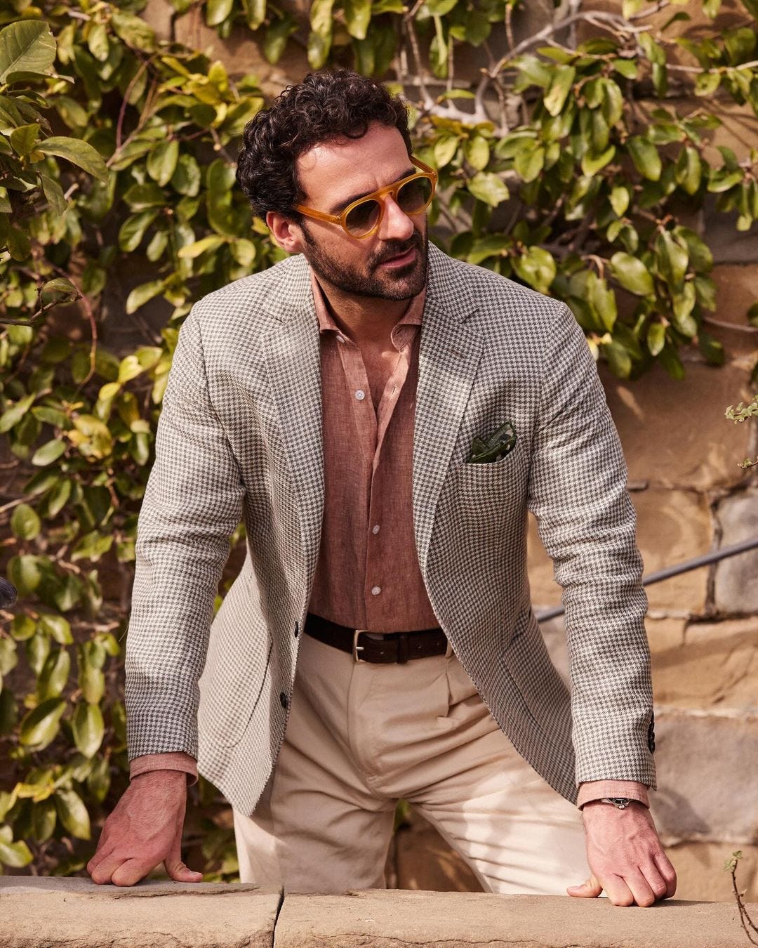 Italian summer outfits inspiration for men, a man wearing a lightweight blazer, linen shirt, and tan pants