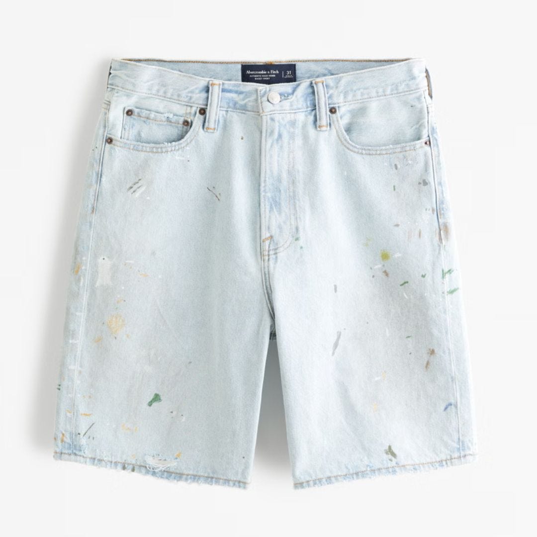 flat lay image of light-rinse jean shorts splattered with paint