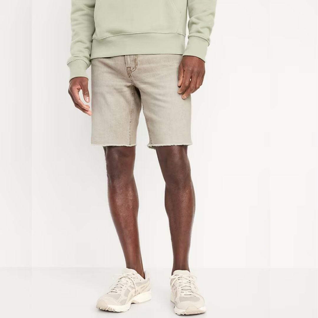 image of a man from the waist down wearing a mint-colored sweatshirt, faded jean shorts, and sneakers