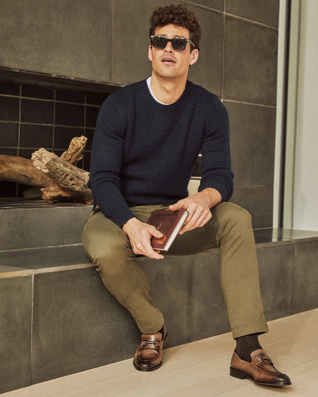 man sitting by the fire place wearing a pair of arezzo loafers by bruno magli