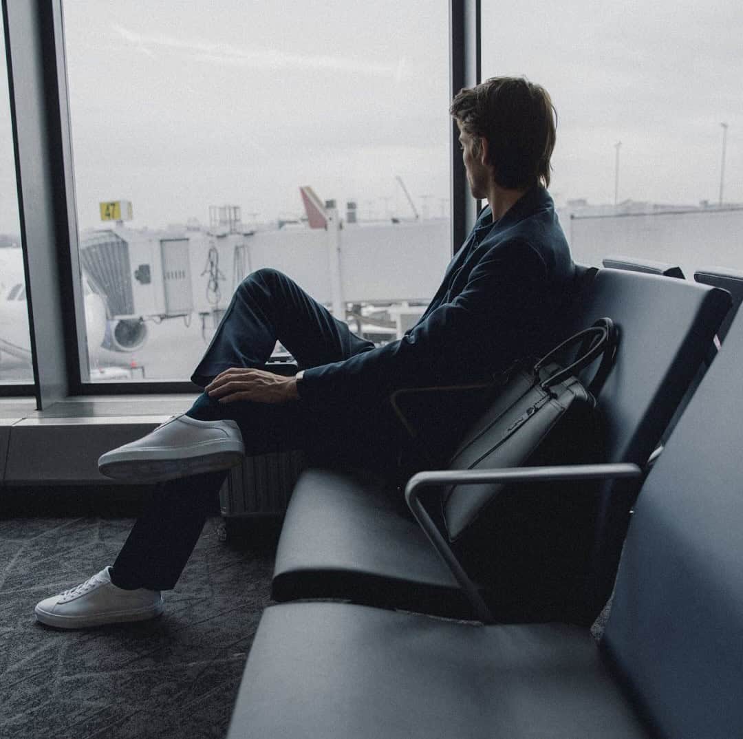 man sitting in the boarding area of an airport