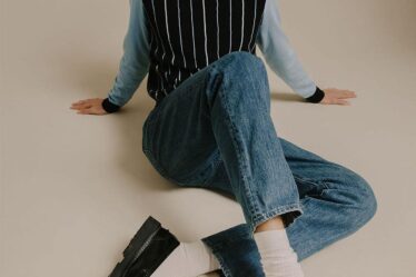 man sitting on the floor wearing a pair of arezzo dice loafers