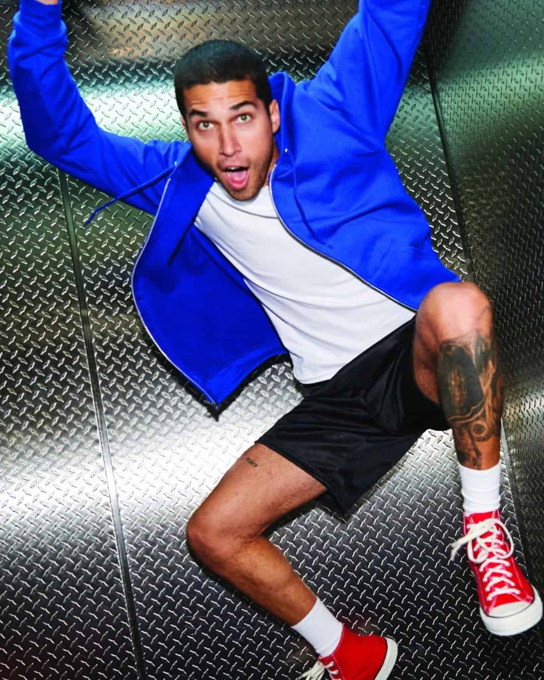 man jumping wearing a blue hoodie and black shorts