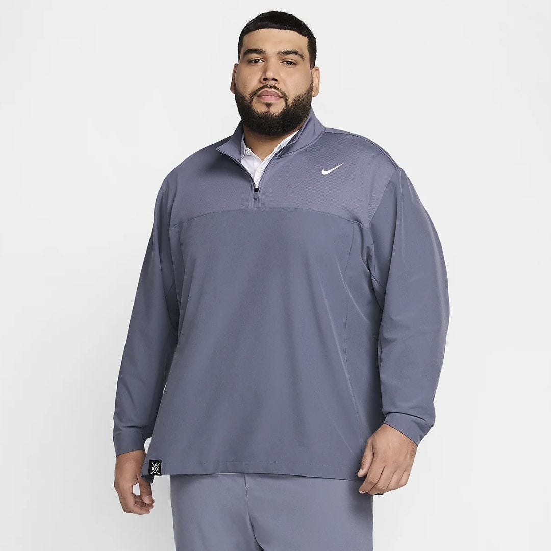 man from the waist up wearing a blueish-purple long-sleeve Nike dri-fit quarter-zip pullover