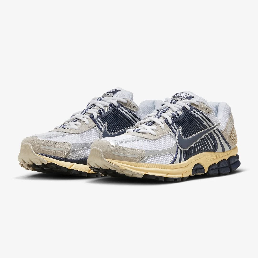 a pair of silver and navy nike zoom vomero 5 sneakers