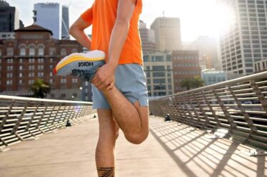 man stretching his legs and wearing a pair of hoka bondi 8