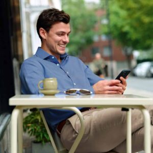 man smiling while checking his phone