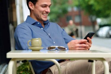 man smiling while checking his phone