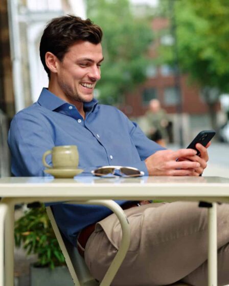man smiling while checking his phone