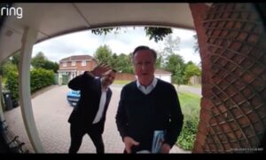 Cameron and another man viewed through doorbell camera outside someone's house