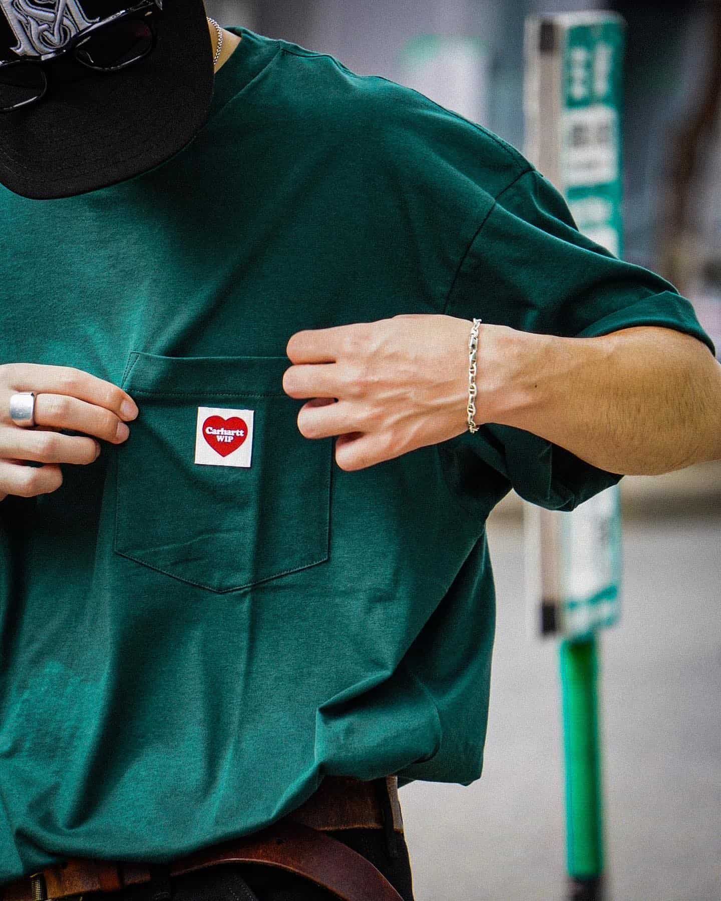 man wearing a green t-shirt with pocket by carhartt wip