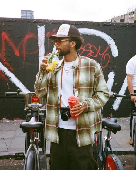 man drinking a fruit juice and holding a cup of diced watermelon