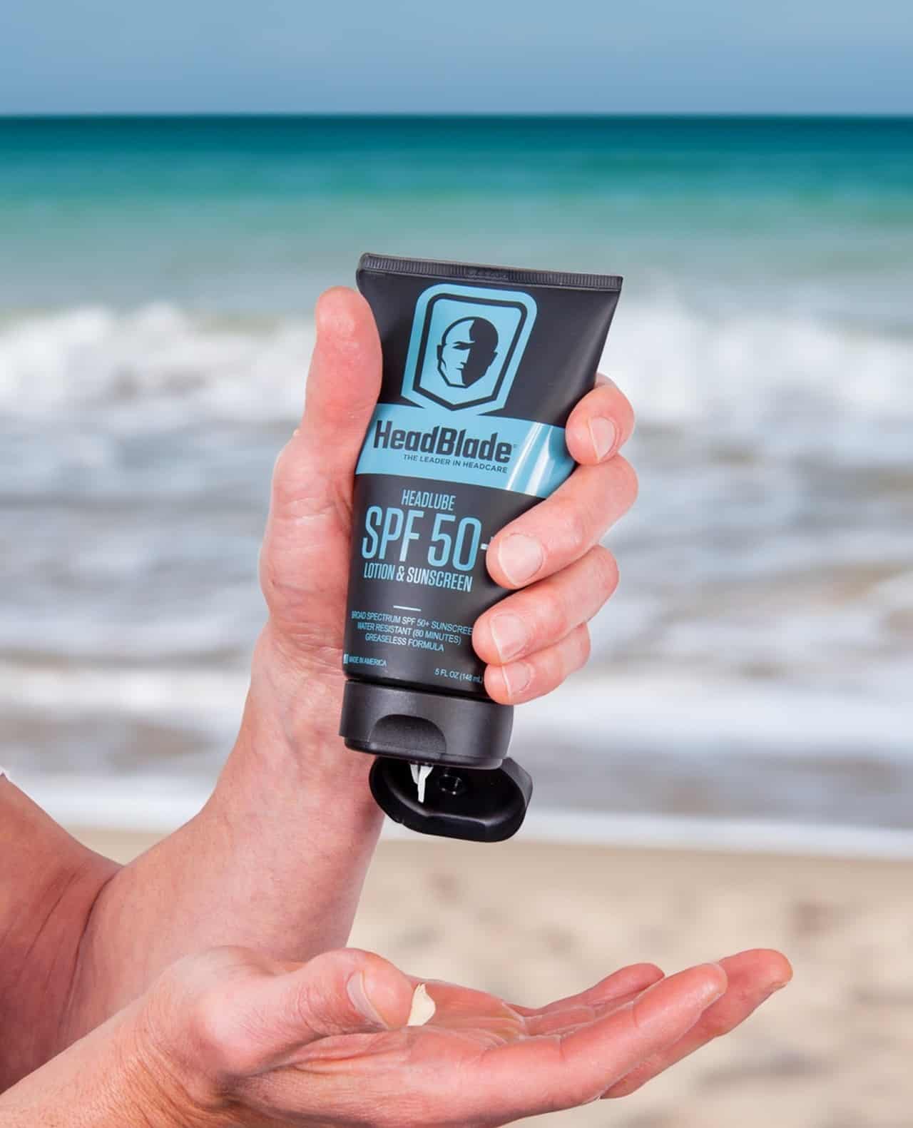 holding a tube of head blade sunscreen