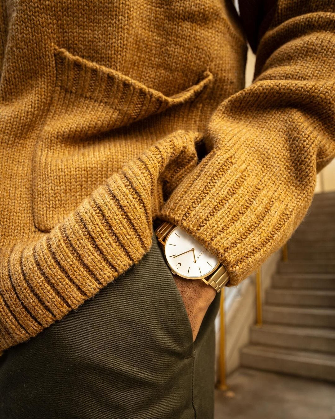 close-up details of a man wearing a cardigan and watch with white face