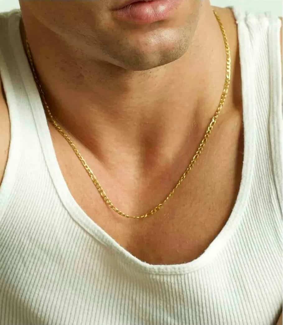 man in a white tank top wearing a gold chain