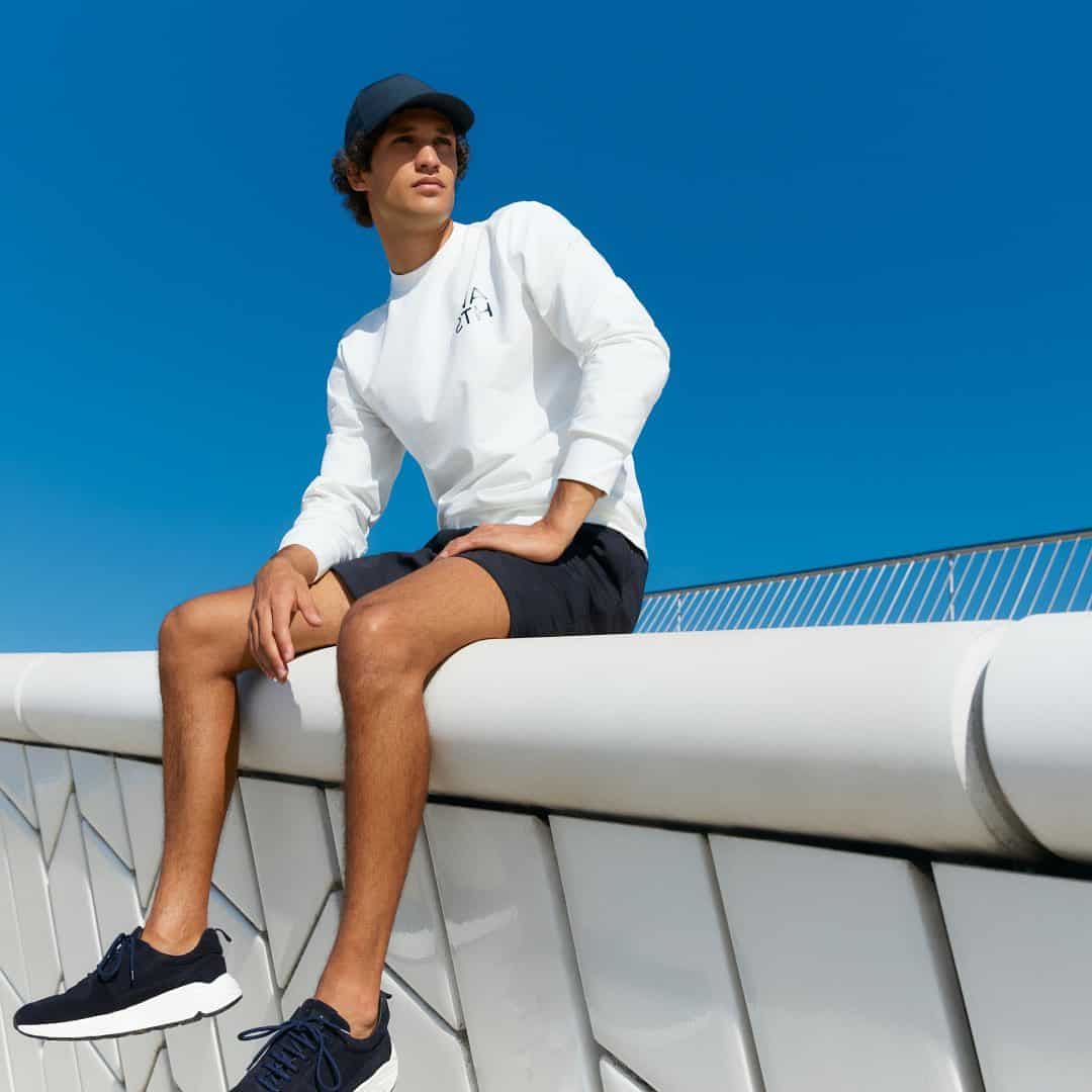 man sitting on a concrete fence