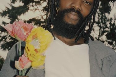 man holding flowers wearing a v neck t-shirt